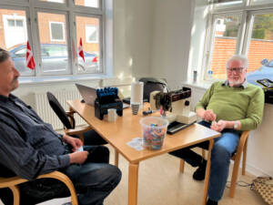 Peter Sørensen (tv.) og årets ildsjæl 2025, H. C. Thordsen, som også er uddannet symaskine finmekaniker, tilbyder hjælp i Reparationscaféen. Foto Helle Hockerup