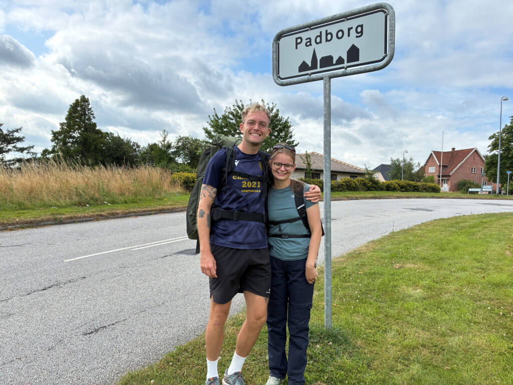 Vandrere ved Padborg-byskiltet på Hærvejen, Danmarks Camino