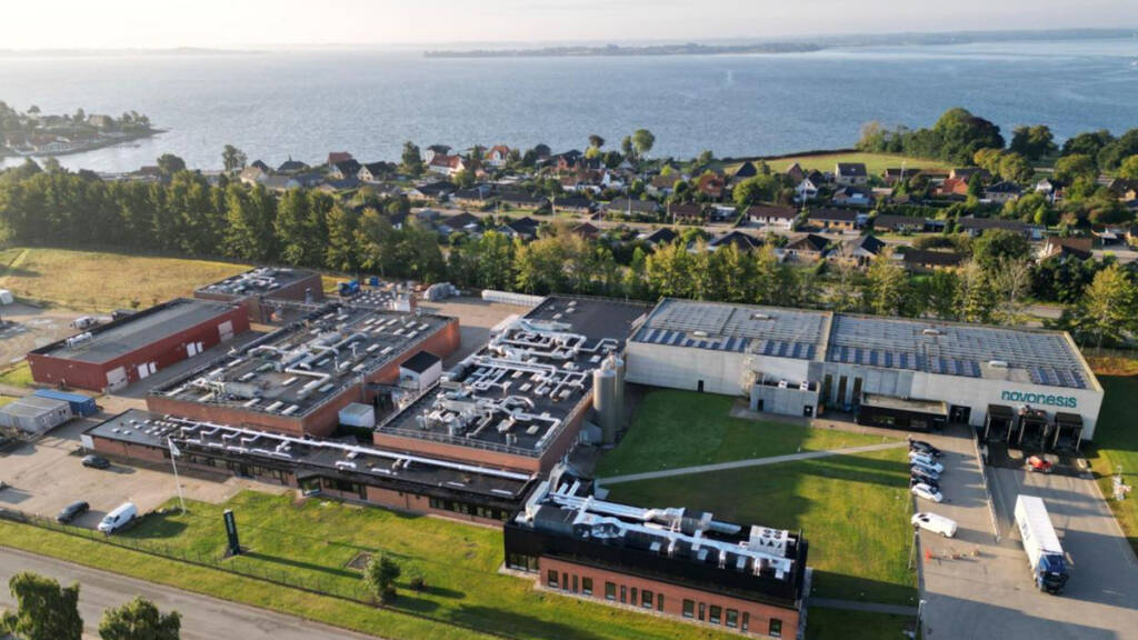 Luftfoto af Novonesis enzymfabrik på Sundsnæs i Gråsten med Flensborg Fjord i baggrunden