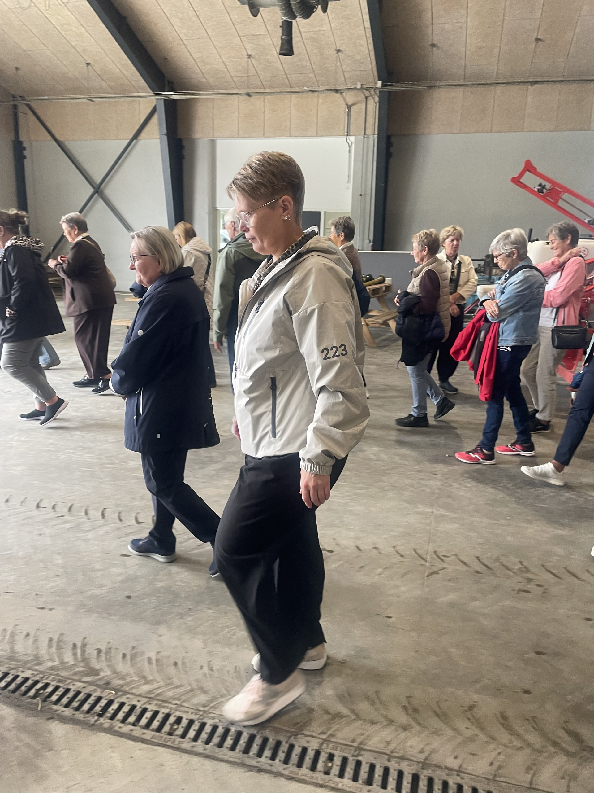Medlemmer af Kruså Husmoderforening på rundvisning i en stor lade på Gråsten Landbrugsskole