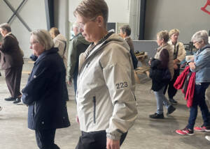 Medlemmer af Kruså Husmoderforening på rundvisning i en stor lade på Gråsten Landbrugsskole