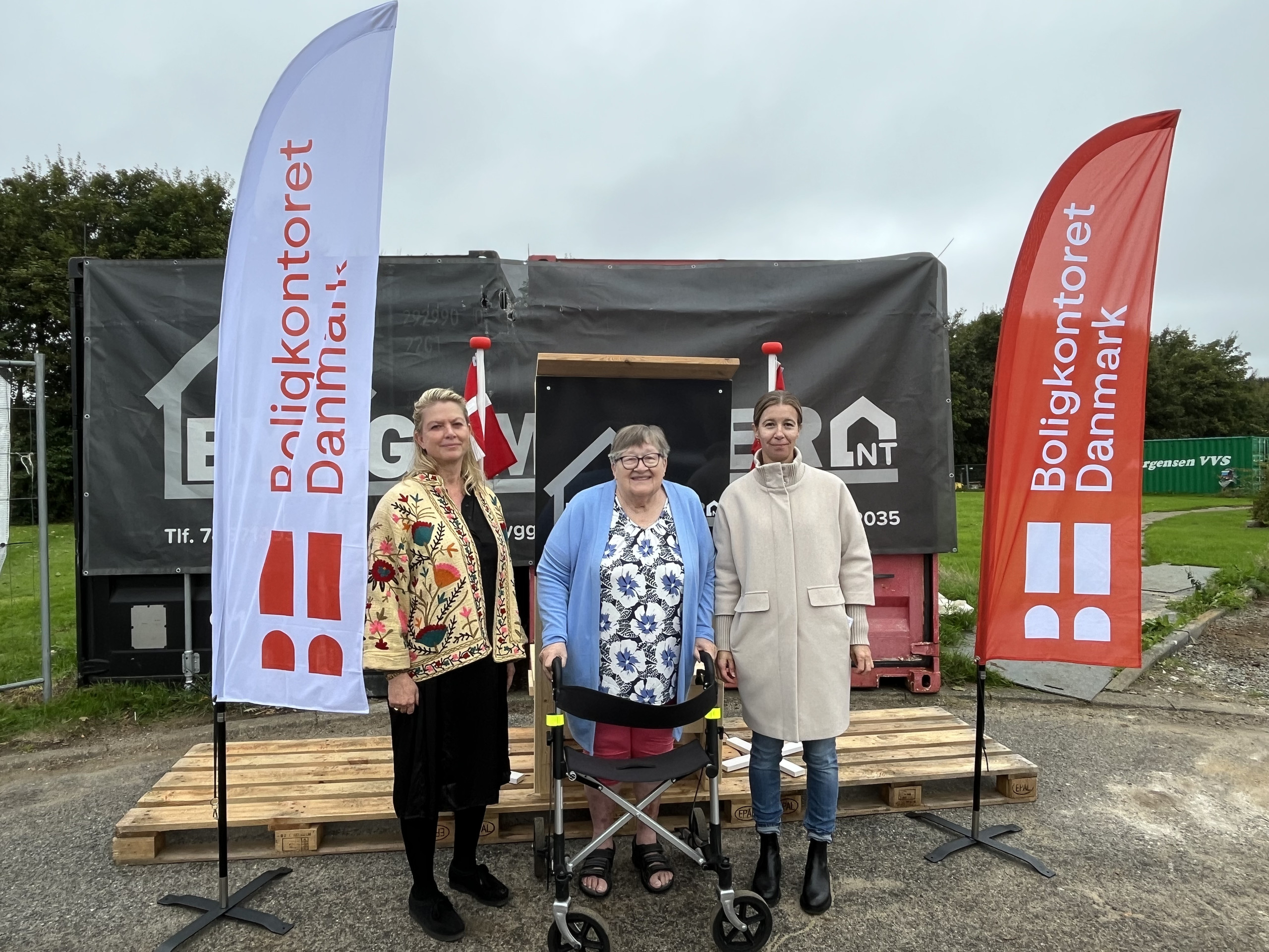 Tre kvinder foran beachflag fra Boligkontoret Danmark ved receptionen på Toften i Padborg