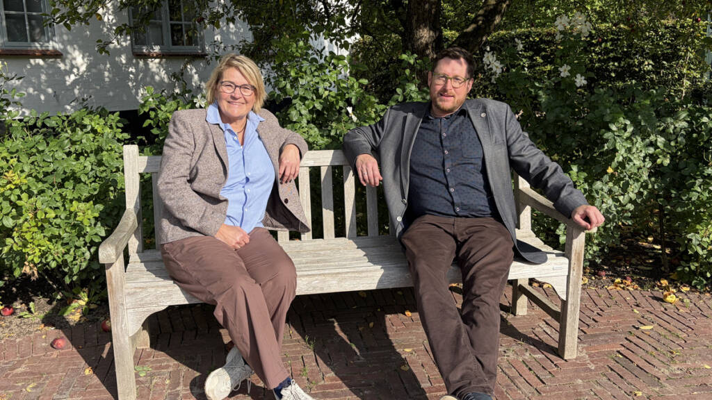 Ingrid Johannsen og Daniel Staugaard sidder på en bænk under træerne i Gråsten