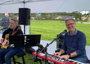 Peter og Preben spiller guitar og keyboard under et telt i Fritidsparken