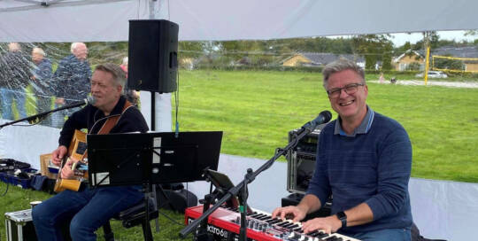 Peter og Preben spiller guitar og keyboard under et telt i Fritidsparken