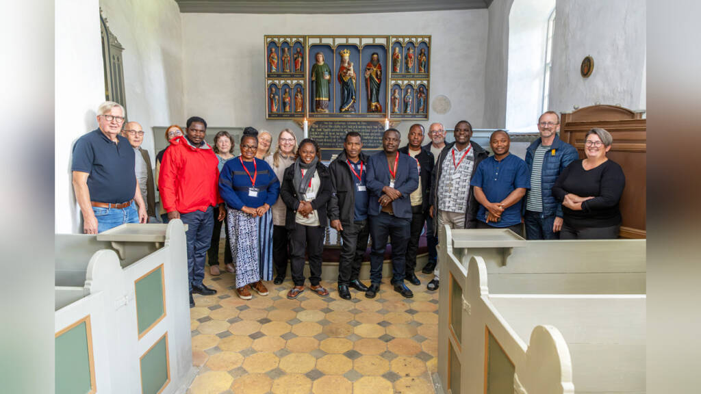 Delegationen fra Tanzania samlet til gruppebillede med værter i Rinkenæs Gamle Kirke