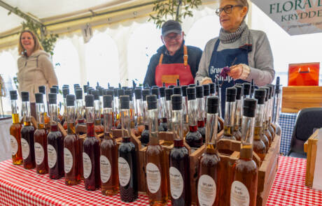 Flasker med æblesaft og likør på et rødternet bord i en bod på Gråsten Æblefestival