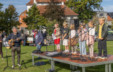 250 skoleelever sang ved Æblefestivalen (3) Elever synger ved mikrofonerne akkompagneret af en guitarist på scenen