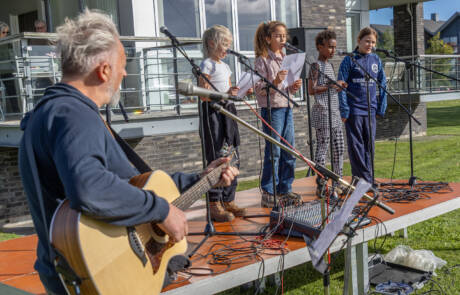 250 skoleelever sang ved Æblefestivalen (4) Guitarist akkompagnerer en gruppe syngende børn på scenen ved Æblefestivalen