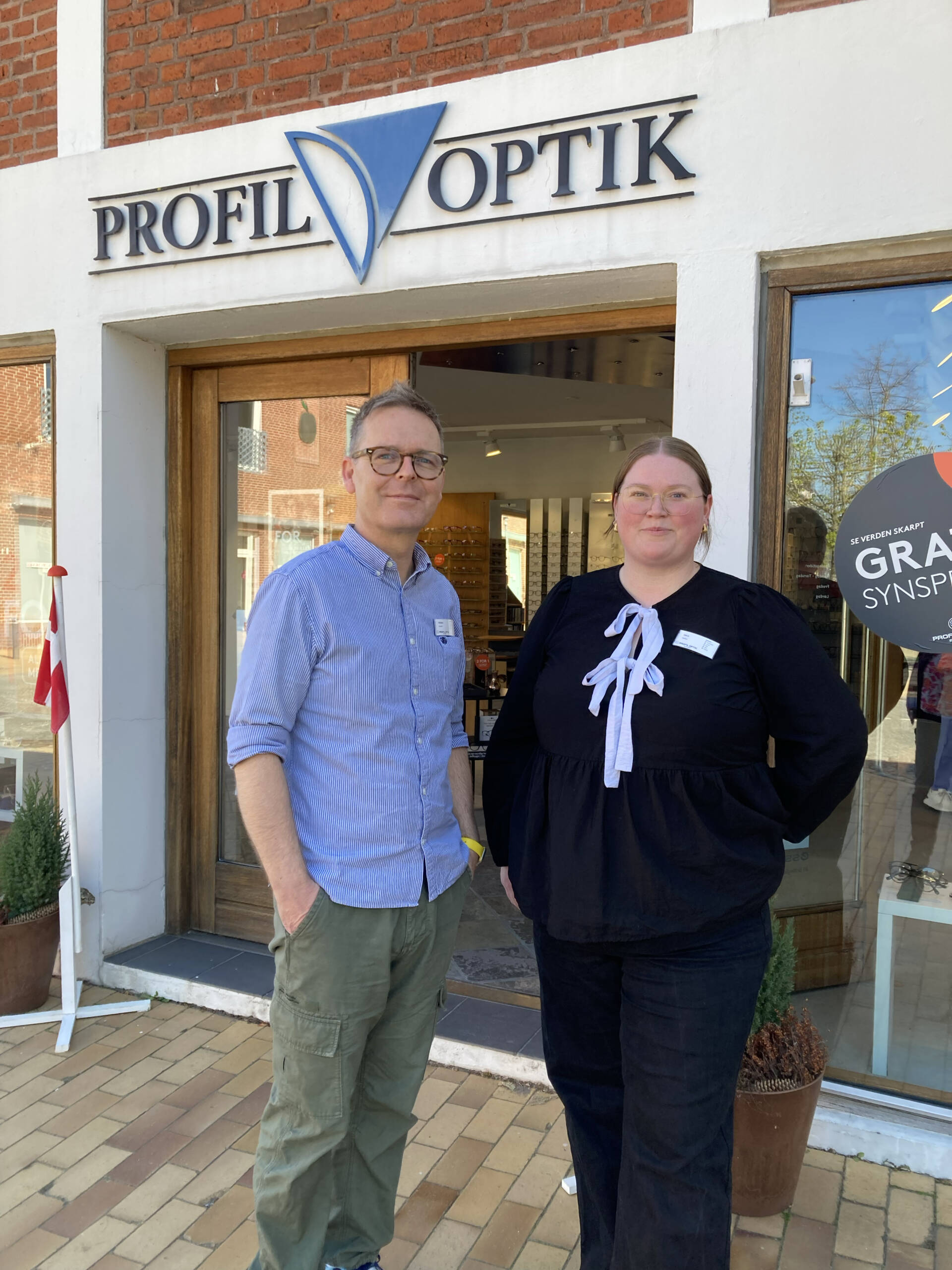 Profil Optik i Graasten Souschef Frederik Snejbjerg Pedersen og optometrist Emilie Brinck Pedersen foran indgangen til Profil Optik i Gråsten