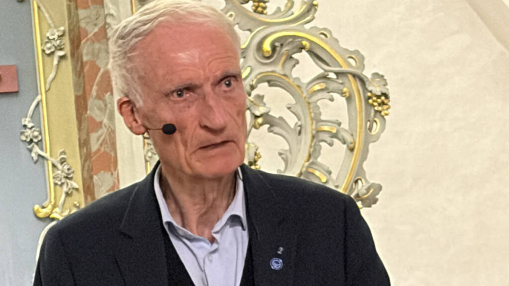 Bertel Haarder taler med løftet hånd foran et rigt udsmykket kirkeinteriør