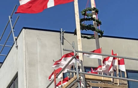Dannebrog og rejsegildekrans hejst på stilladset over H.P. Therkelsens nybyggeri i Padborg Vest