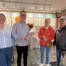 Fire personer står smilende foran en butiksdisk i den nyrenoverede optikerbutik Profil Optik i Gråsten