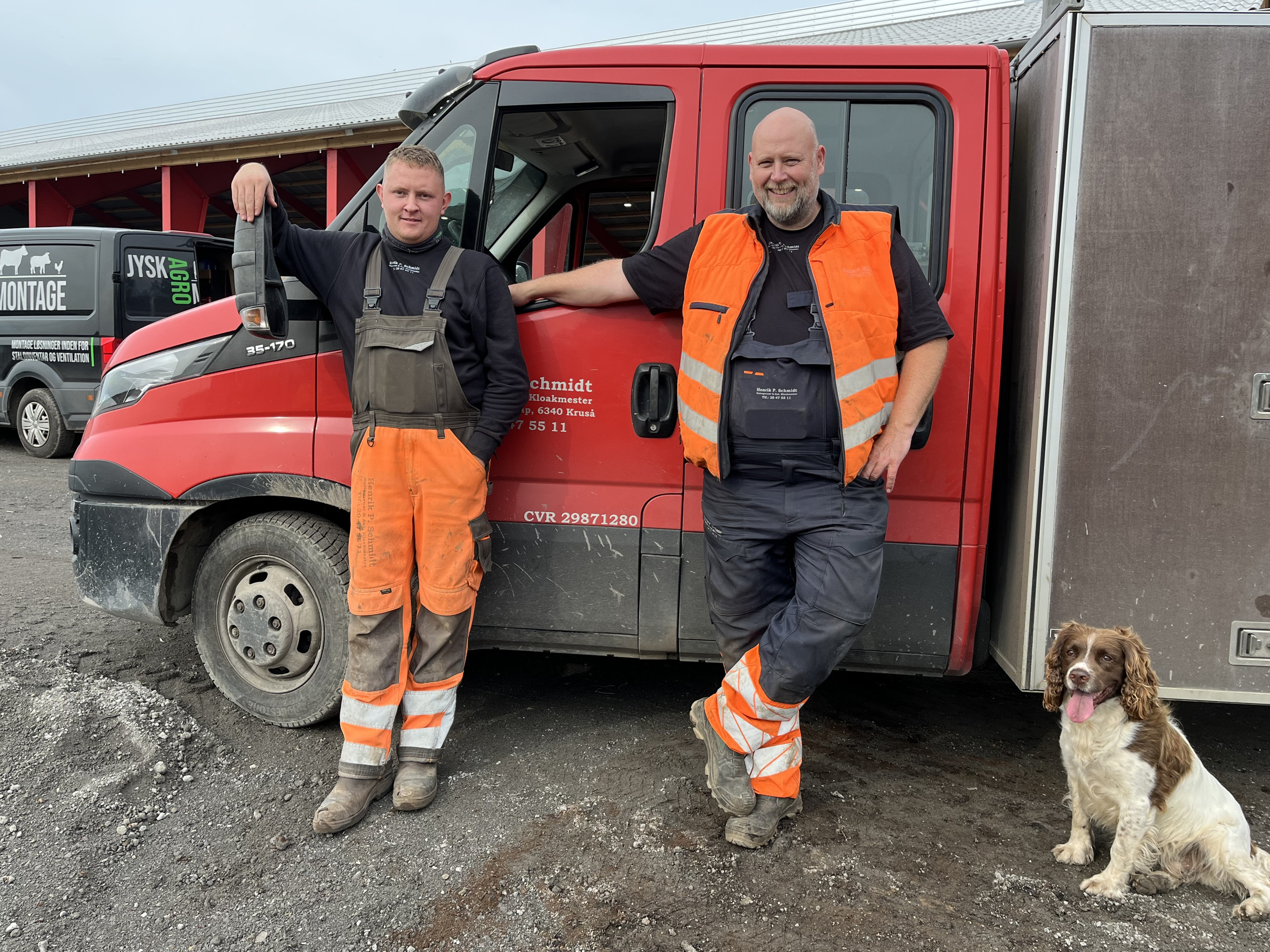 Tre 12-taller sikrede Nicklas sjælden bronzemedalje (2) To anlægsfolk i arbejdstøj ved en rød varevogn med en hund på byggepladsen