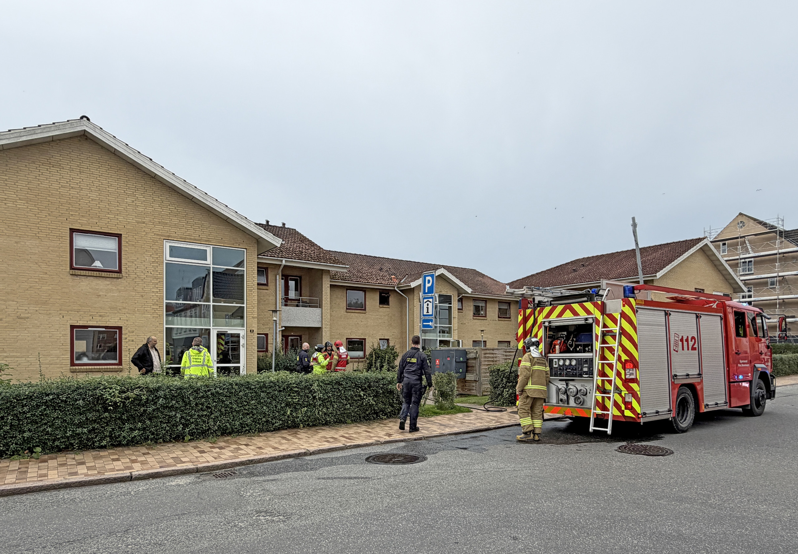 Tre på skadestuen efter voldsom brand (2) Brandbil holder foran boligblokken i Domhusparken i Gråsten under slukningsarbejdet