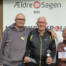 Tre personer står foran et skilt fra Ældre Sagen Bov, og en af dem holder en pokal